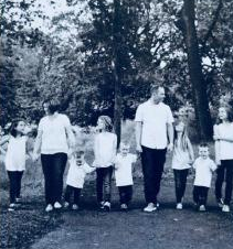 Family holding hands outdoors in an earlier season