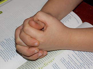 Hands resting on an open Bible