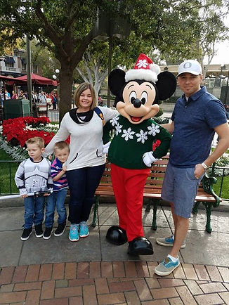 Family members and two young boys posing beside a costumed character